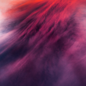 A swirling blend of deep reds and purples creating a dreamy, abstract atmosphere.