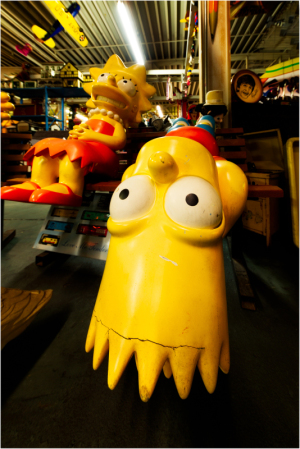 Vibrant yellow figures of Bart and Lisa Simpson in a nostalgic toy shop.