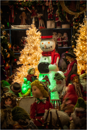 Whimsical holiday scene with a glowing snowman and festive decorations.