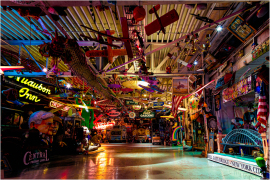 A vibrant collection of neon signs and eclectic memorabilia fills a dimly lit space.