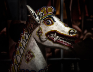 Colorful horse head sculpture with a fierce expression and intricate designs.