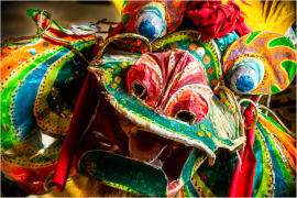 Vibrant dragon mask adorned with colorful patterns and textures.
