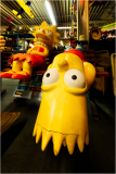 Vibrant yellow figures of Bart and Lisa Simpson in a nostalgic toy shop.