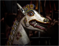 Colorful horse head sculpture with a fierce expression and intricate designs.