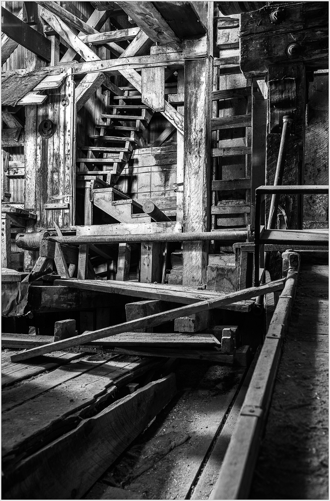 Historic wooden infrastructure with stairs and beams in a dimly lit space