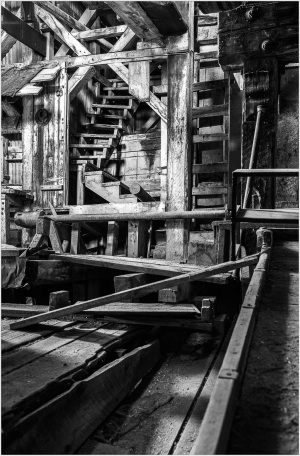Historic wooden infrastructure with stairs and beams in a dimly lit space