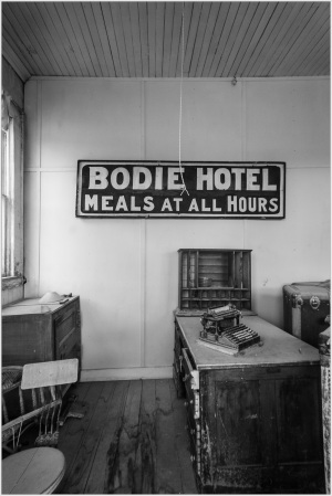 Interior of Bodie Hotel featuring a sign for meals, capturing a glimpse of historic hospitality.