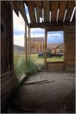 Inside a decaying building, remnants of a past community linger in the shadows.
