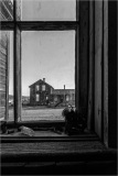 View through a window showcasing historic buildings in Bodie, California.