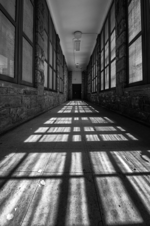 A hallway bathed in striped shadows and light, creating a dramatic effect.
