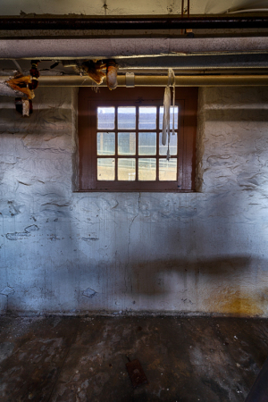 Interior view of a basement with stone walls and a small window.