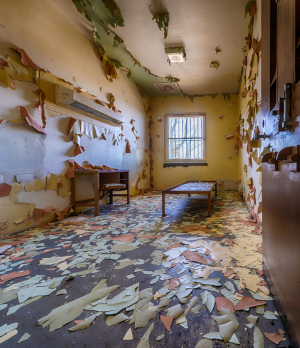 Interior of an abandoned room with peeling paint and debris on the floor
