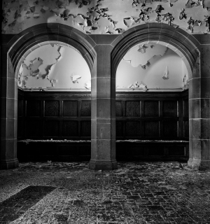 Two crumbling arches frame a peeling wall, reminiscent of a ghostly game of peek-a-boo.