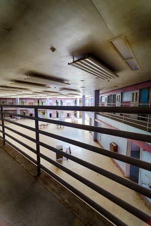 Interior view of a spacious, empty hall with railings and overhead lighting