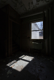 Dimly lit room with a window casting shadows on the floor