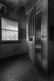 Interior view of a vintage elevator shaft with metal door and tiled floor.