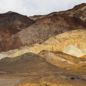 A dramatic landscape of layered hills in Death Valley, showcasing earthy tones and textures.