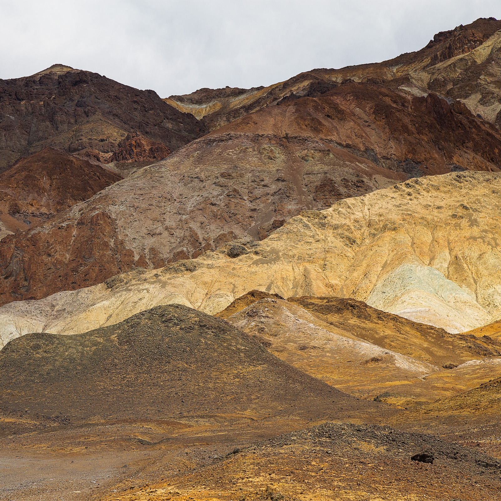 A dramatic landscape of layered hills in Death Valley, showcasing earthy tones and textures.