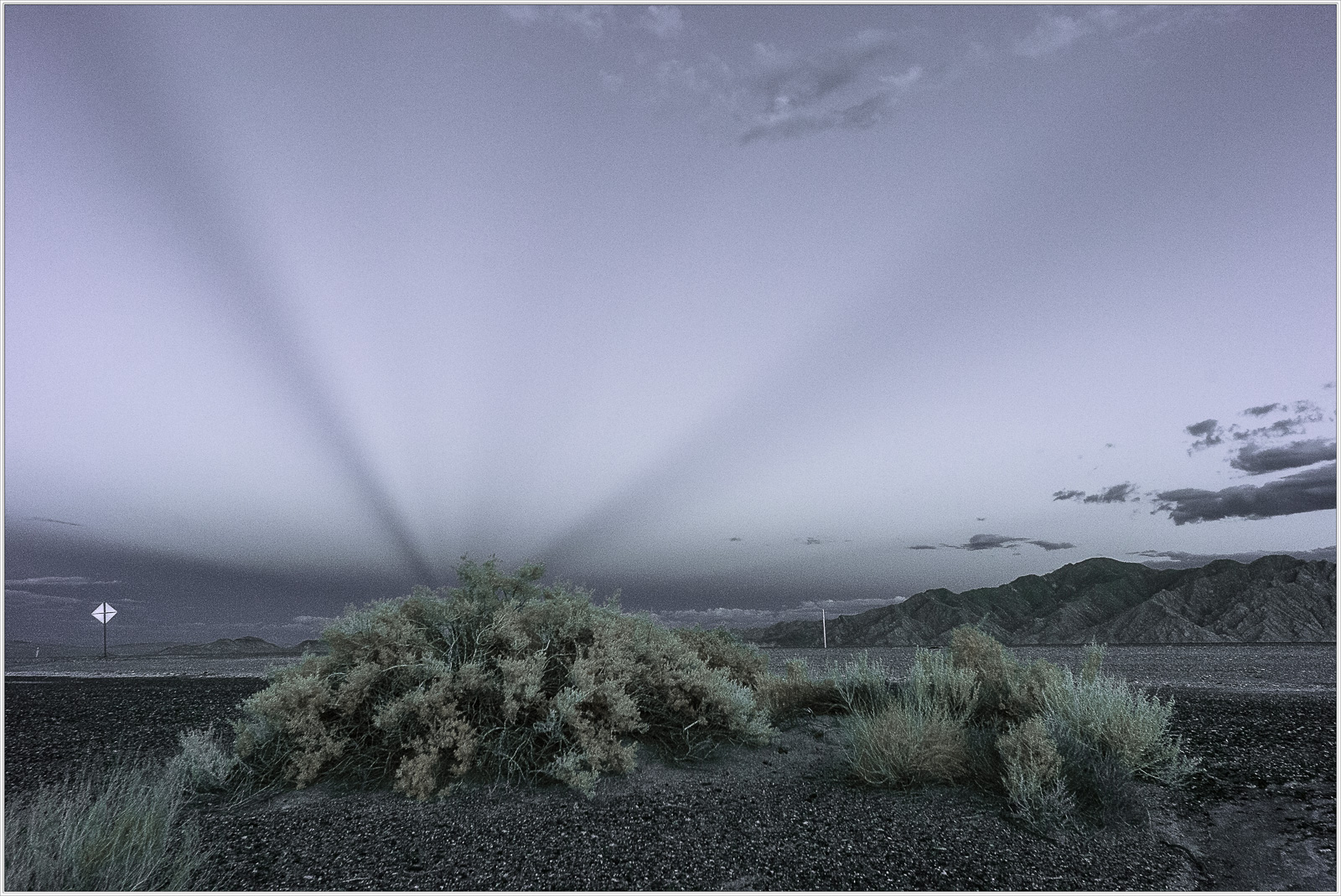 A surreal landscape in Death Valley, shadows stretching across the desert under a twilight sky.