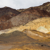 A dramatic landscape of layered hills in Death Valley, showcasing earthy tones and textures.