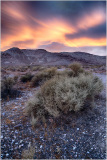 A surreal desert landscape with vibrant skies and rugged mountains.