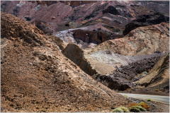 A rugged landscape of earthy tones and textured hills in Death Valley.