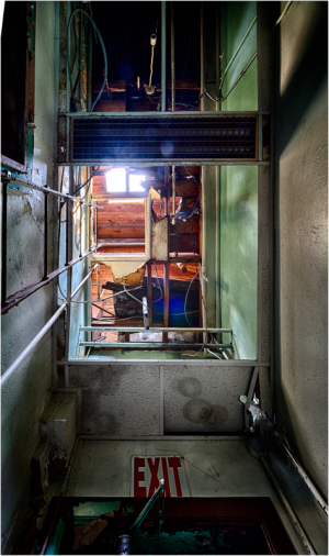 A dimly lit corridor with an exit sign and visible pipes, creating a sense of mystery.