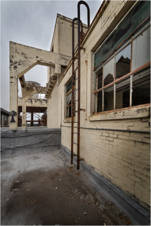 A dilapidated industrial building with peeling paint and rusted structures.