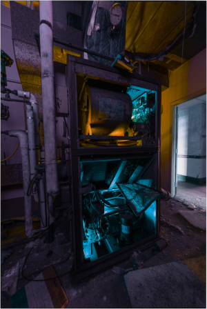 An enigmatic machine cornered in vibrant blues and grimy shadows.