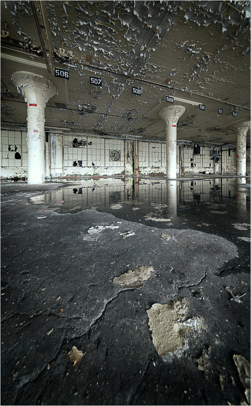 Abandoned space with cracked floor and peeling walls, haunting and raw.