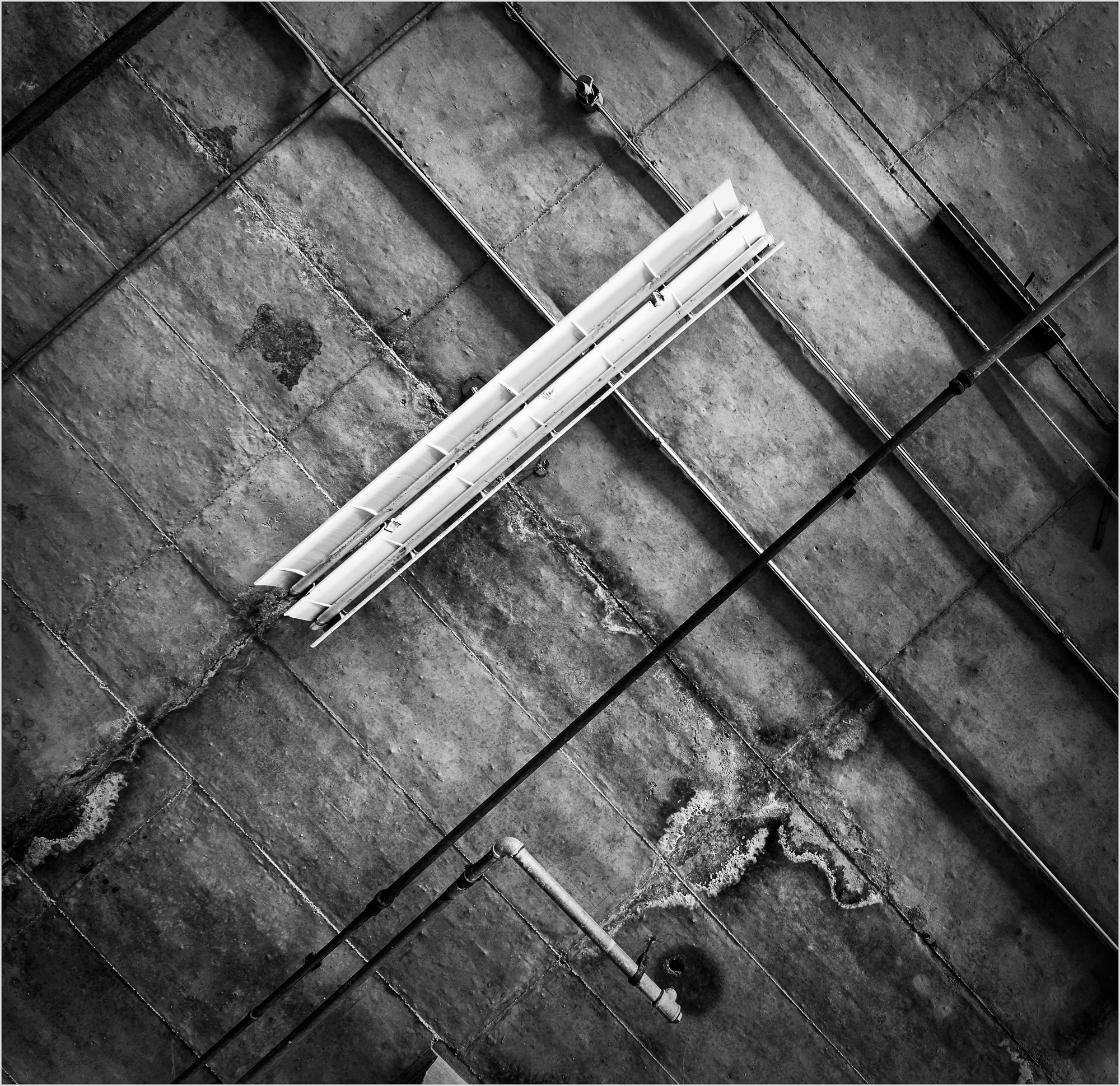 An overhead view of a textured surface with lines and a light fixture.