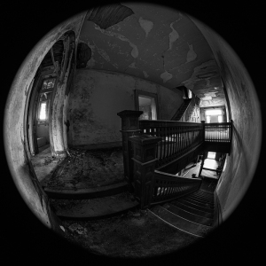 abandoned staircase in a dimly lit, peeling wall interior, eerie atmosphere