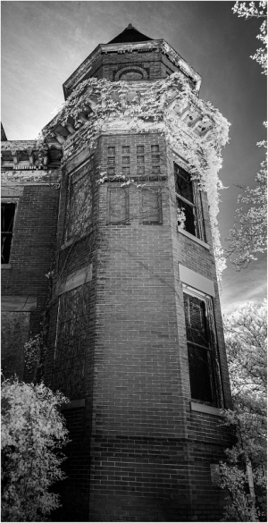 A weathered brick tower with peeling paint, hinting at forgotten stories and a history gone gray.