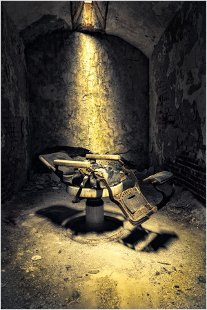 An old, rusty electric chair in a dimly lit prison cell.