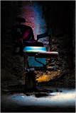 An old dental chair in a dimly lit room with colorful lighting.