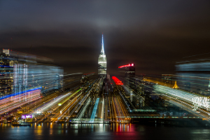 A blurred view of the Empire State Building amidst city lights at night.