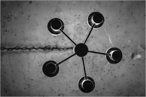 A surreal chandelier of shadows, five luminous orbs twist and swirl in a dance of light and darkness.