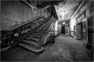 Interior of Everett Square Theatre showing a worn staircase and peeling walls.