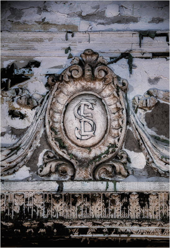 A weathered emblem with an intricate design, showing age and history.