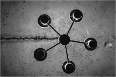 A surreal chandelier of shadows, five luminous orbs twist and swirl in a dance of light and darkness.