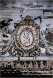 A weathered emblem with an intricate design, showing age and history.