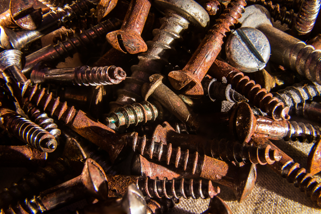 A chaotic mix of rusty screws and bolts, each with its own story of wear and tear.