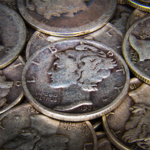 A pile of vintage coins featuring various designs and dates.