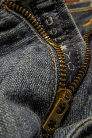 Close-up of a denim zipper with the words 'I love you' stitched inside.