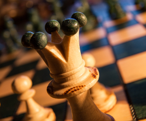 A close-up of a wooden chess queen with a regal crown, poised for cosmic conquest.