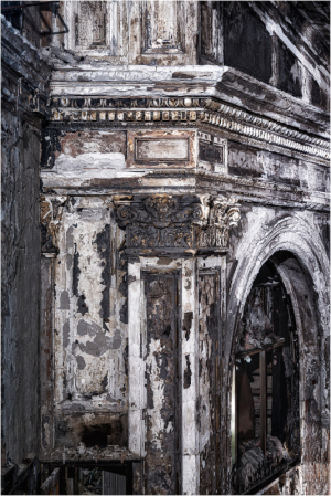 A decaying theater interior with peeling paint and shadows.