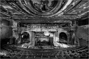 Abandoned theater with peeling paint and empty seats, shadows lurking in corners.