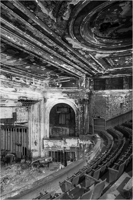 Abandoned theater with peeling paint and empty seats, shadows lurking in corners.