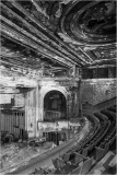 Abandoned theater with peeling paint and empty seats, shadows lurking in corners.