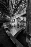 Abandoned theater interior with peeling paint and shadows.